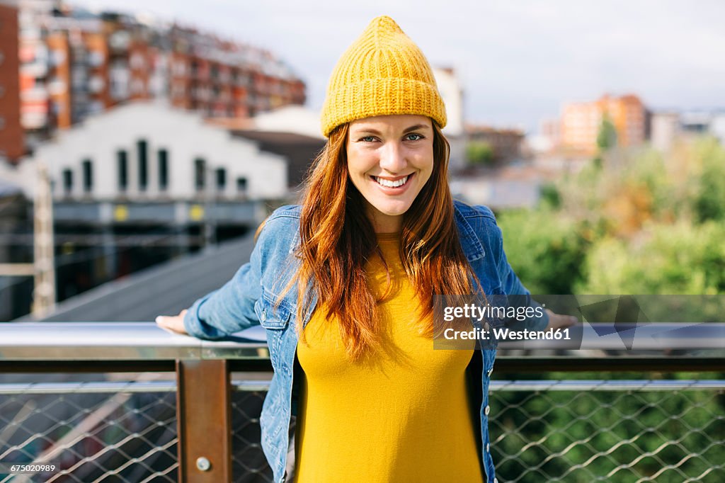 Portrait of smiling young woman wearing yellow cap and dress