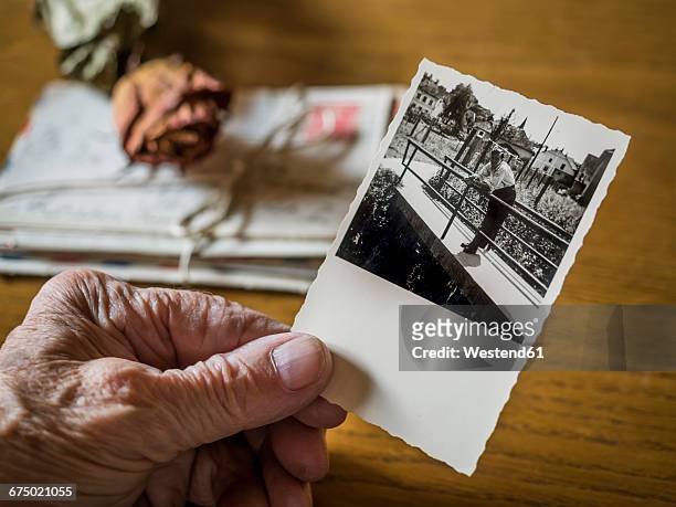 old woman holding picture of her boyhood friend in hand, old letters and dried rose - ラブレター ストックフォトと画像