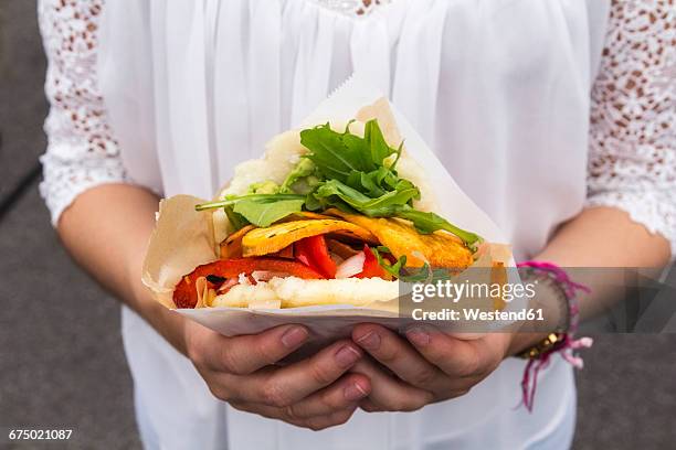 hands of teenage girl holding corn flat bread stuffed with vegetables - seleccion colombia stock-fotos und bilder