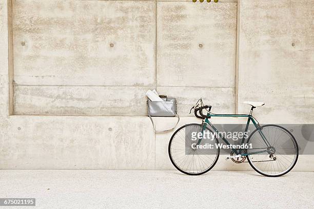 bicycle at concrete wall and bag in ledge - sims stock-fotos und bilder
