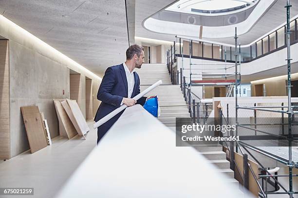 architect in office building looking around - architect industrie stock-fotos und bilder