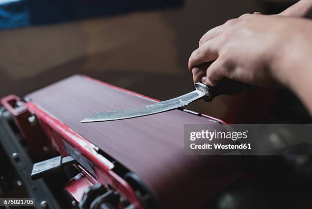 forger sharpening knife in workshop - metal sanding stock pictures, royalty-free photos & images
