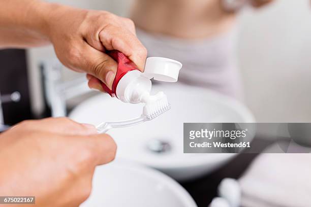 man's hands applying toothpaste on toothbrush, close-up - 歯みがき粉 ストックフォトと画像
