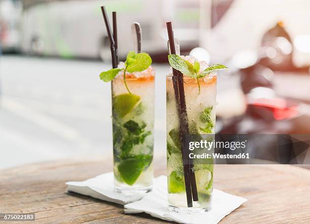 two glasses of mojito on table of sidewalk cafe - モヒート ストックフォトと画像