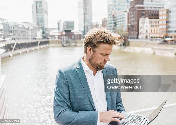 businessman on bridge using laptop - medienhafen stock pictures, royalty-free photos & images