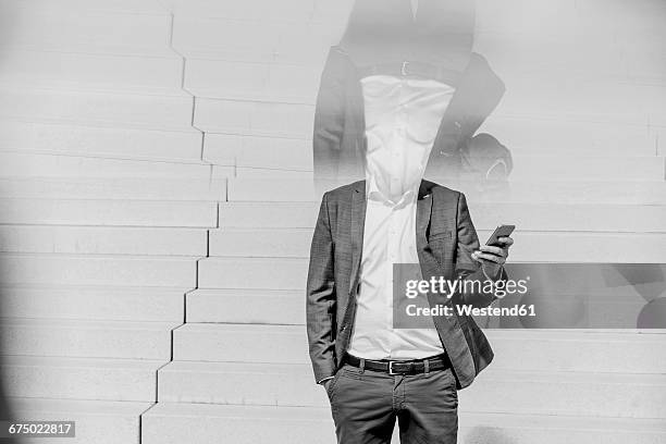 businessman standing on stairs holding cell phone - headless man 個照片及圖片檔