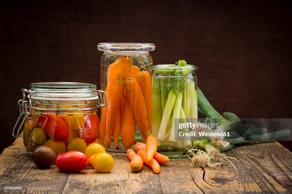 Pickled spring onions and fermented carrots in glasses