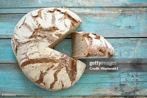 rustic rye bread on blue wood - roggebrood stockfoto's en -beelden