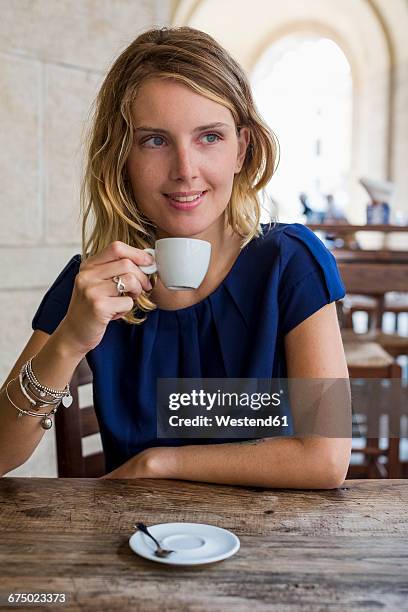 portrait of smiling blond woman drinking espresso in a sidewalk cafe - espresso drink stock pictures, royalty-free photos & images