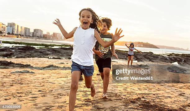 kids running on the beach at sunset - gijon bildbanksfoton och bilder