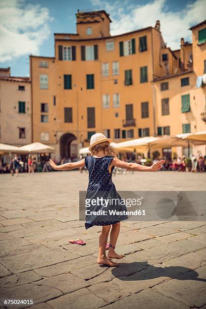 italy, lucca, back view of little girl dancing at the piazza dell'anfiteatro - lucca italy stock pictures, royalty-free photos & images