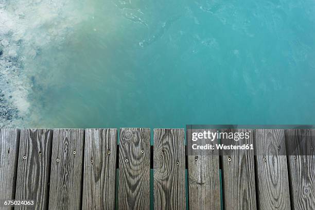 iceland, reykjanes, wooden boardwalk and water of blue lagoon - voetgangersbrug stockfoto's en -beelden