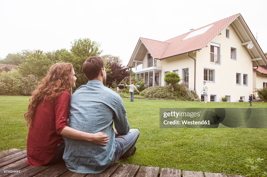 Couple in garden looking at house