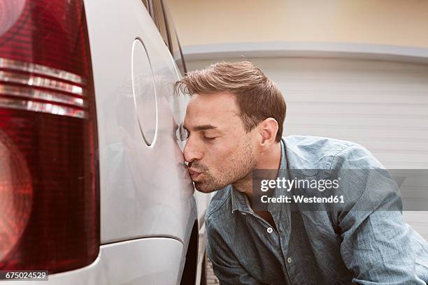 man kissing his clean car - kuss stock-fotos und bilder