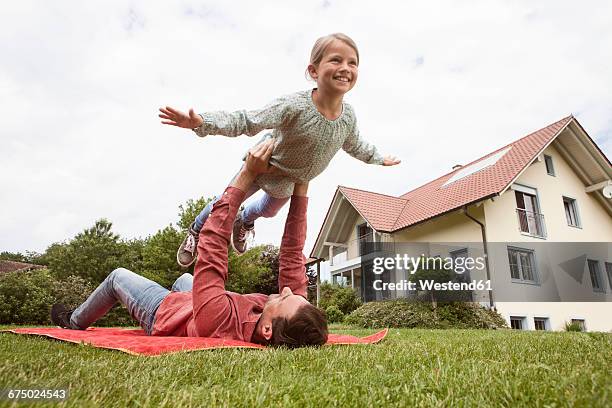 father playing with daughter in garden - pretending to be a plane stock pictures, royalty-free photos & images