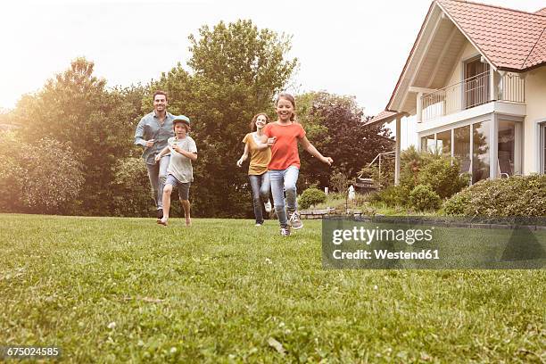 carefree family running in garden - house of families stock pictures, royalty-free photos & images