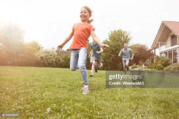 carefree family running in garden - race 8 stock pictures, royalty-free photos & images