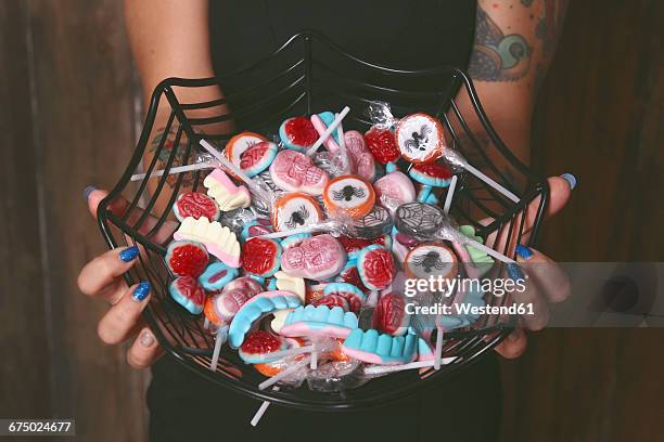 woman offering halloween candies, close-up - halloween candy stock-fotos und bilder