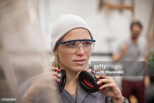 woman wearing safety goggles and earmuffs in workshop - ear protection 個照片及圖片檔