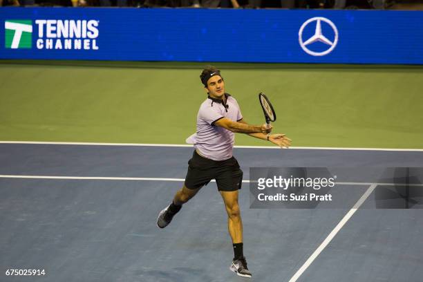 Roger Federer of Switzerland returns a serve against John Isner of the United States at the Match For Africa 4 exhibition match at KeyArena on April...