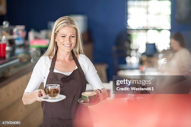 waitress serving coffee and tea in a cafe - women serving coffee stock-fotos und bilder