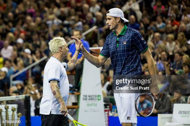 Musician Mike McCready high fives John Isner of the United States at the Match For Africa 4 exhibition match at KeyArena on April 29, 2017 in...
