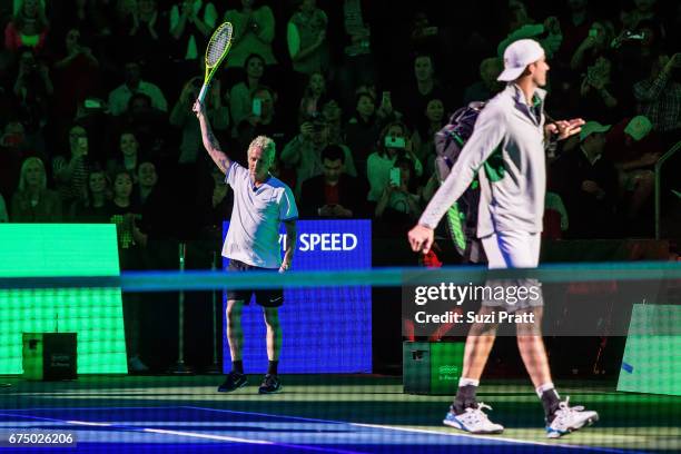 Musician Mike McCready and John Isner of the United States enter the tennis court at the Match For Africa 4 exhibition match at KeyArena on April 29,...