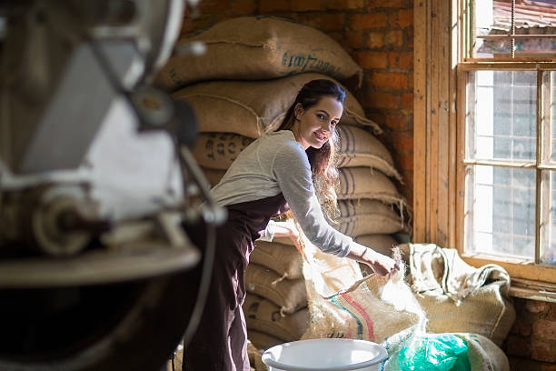 young woman roasting coffee beans - professional coffee roaster stock pictures, royalty-free photos & images