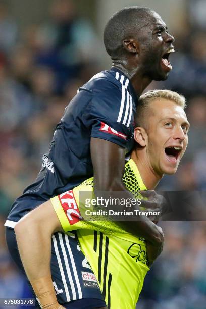 Jason Geria and Victory goalkeeper Lawrence Thomas celebrate their teams win during the A-League Semi Final match between Melbourne Victory and the...