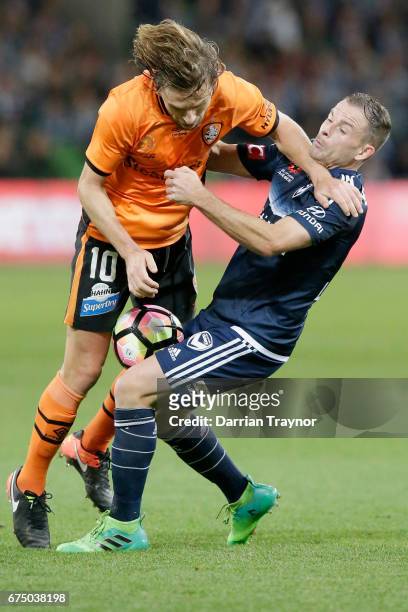 Brett Holman of the Roar and Leigh Broxham of the Victory compete for the ball during the A-League Semi Final match between Melbourne Victory and the...