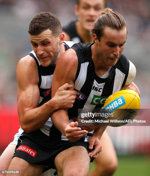 Tim Broomhead of the Magpies is tackled by Sam Menegola of the Cats during the 2017 AFL round 06 match between the Geelong Cats and the Collingwood...