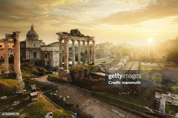 roman forum bei sonnenaufgang, von links nach rechts: tempel des vespasian und titus, kirche santi luca e martina, septimius severus-bogen, ruinen der tempel des saturn. - ancient rome stock-fotos und bilder