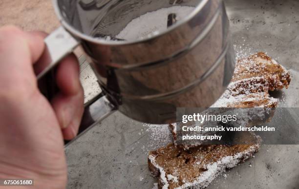 sifting icing sugar on bread pudding. - flour sifter stock pictures, royalty-free photos & images