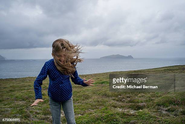 young girl in strong wind on ireland coast - all weather stock pictures, royalty-free photos & images