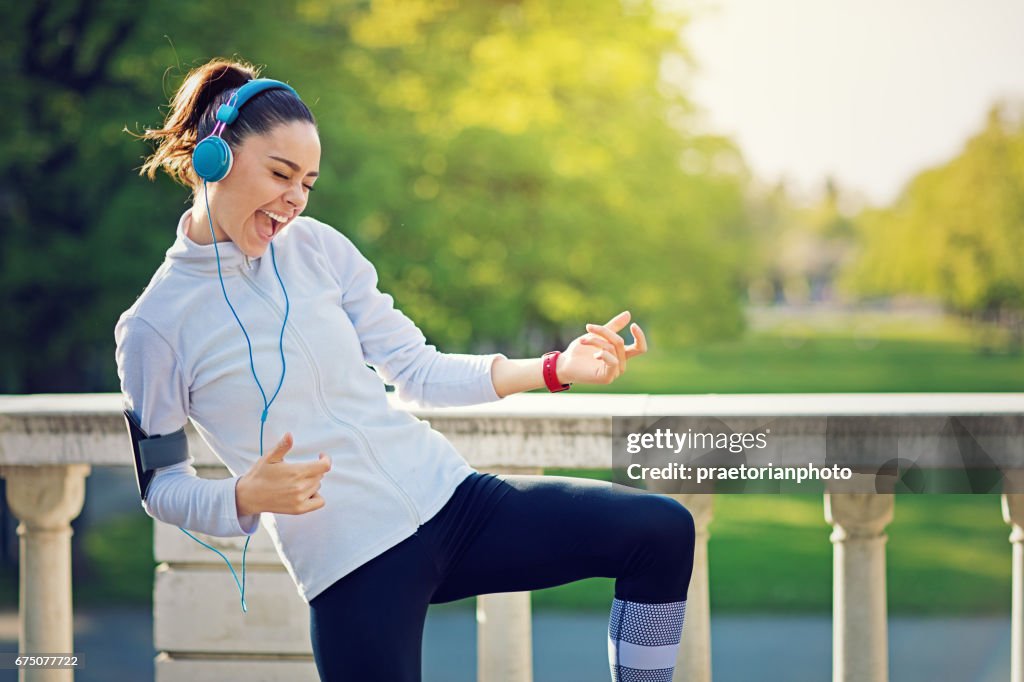 Runner girl is pretend playing guitar at her favorite song