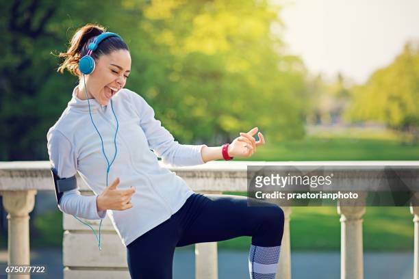 runner girl is pretend playing guitar at her favorite song - girl headphones imagens e fotografias de stock