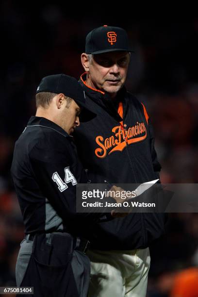 Bruce Bochy of the San Francisco Giants announces a lineup change to umpire Mark Wegner during the seventh inning against the San Diego Padres at...