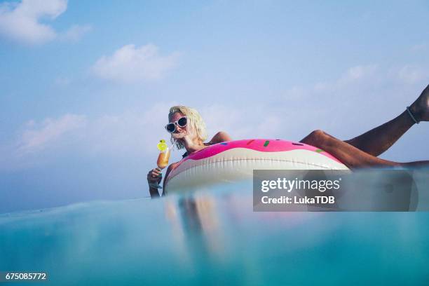 frau trinken cocktail in den ozean, malediven - urlaub frau strand sonne blond kurze haare stock-fotos und bilder