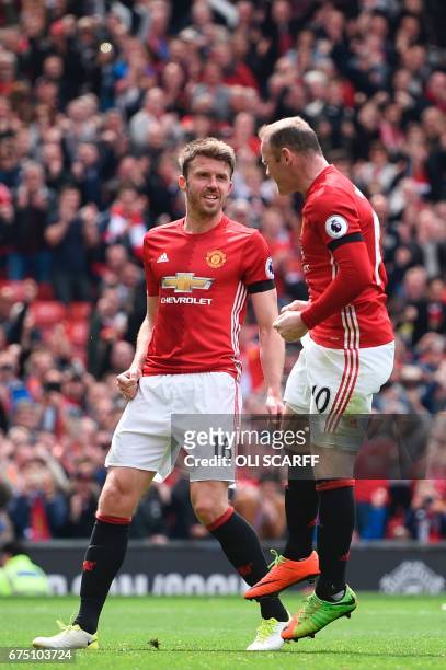 Manchester United's English striker Wayne Rooney celebrates with Manchester United's English midfielder Michael Carrick after scoring the opening...