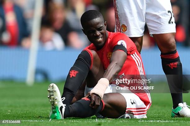 Manchester United's Ivorian defender Eric Bailly sits on the pitch injured during the English Premier League football match between Manchester United...