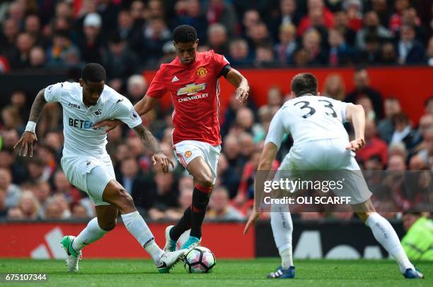 Swansea City's Dutch midfielder Leroy Fer and Swansea City's Argentinian defender Federico Fernandez challenge Manchester United's English striker...