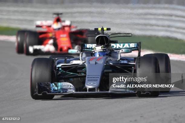 Mercedes' Finnish driver Valtteri Bottas and Ferrari's German driver Sebastian Vettel compete in the Formula One Russian Grand Prix at the Sochi...