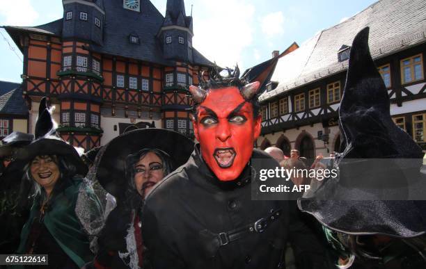 People dressed as witches and as a devil pose on the market square of Wernigerode, central Germany, on April 30 as they celebrate the so-called...