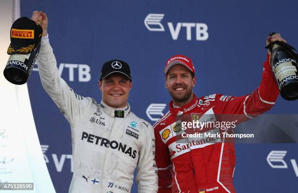 Race winner Valtteri Bottas of Finland and Mercedes GP celebrates with second placed finisher Sebastian Vettel of Germany and Ferrari on the podium...