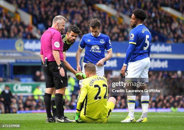 Jonathan Moss checks that Maarten Stekelenburg of Everton is okay as he is helped up by Diego Costa of Chelsea during the Premier League match...