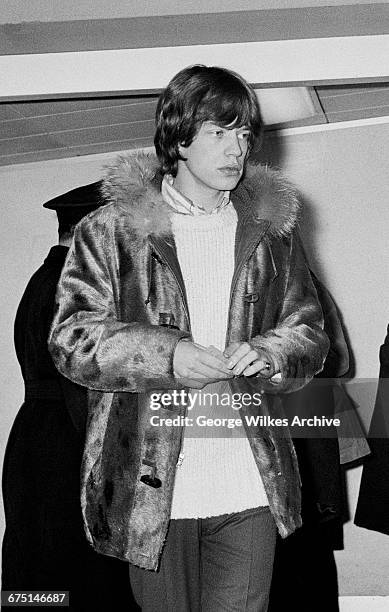 Singer Mick Jagger of The Rolling Stones wearing a parka coat with a fur-lined hood, London, 26th February 1964.