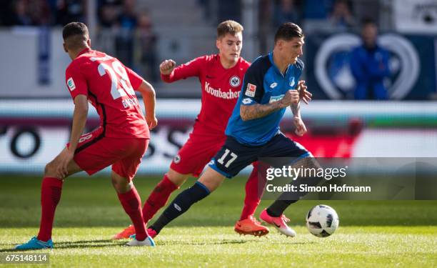 Steven Zuber of Hoffenheim is challenged by Guillermo Varela of Frankfurt during the Bundesliga match between TSG 1899 Hoffenheim and Eintracht...