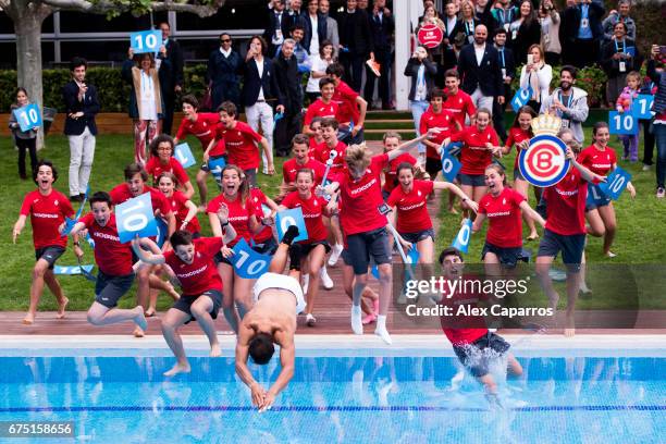 Rafael Nadal of Spain dives in the swimming pool with ballboys after his victory against Dominic Thiem of Austria in their final match on day seven...