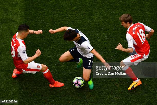 Granit Xhaka of Arsenal and Nacho Monreal of Arsenal attempt to tackle Heung-Min Son of Tottenham Hotspur during the Premier League match between...