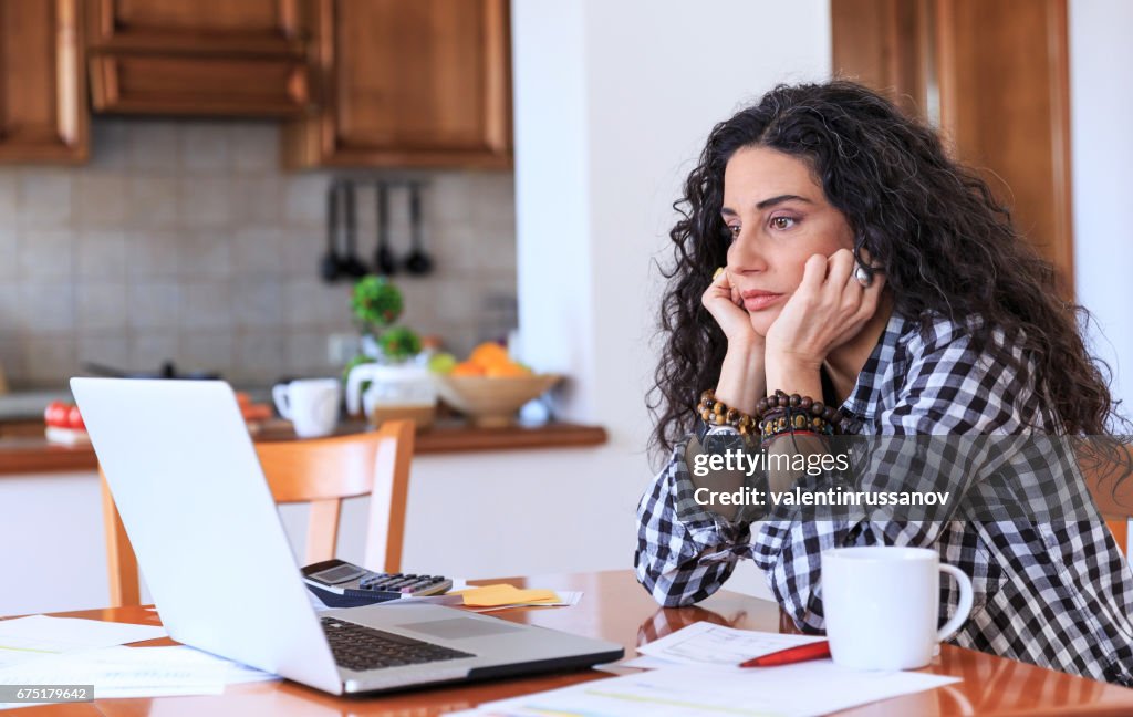 Worried woman sitting at home